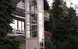 Glasaufzug außen neben Einfamilienhaus