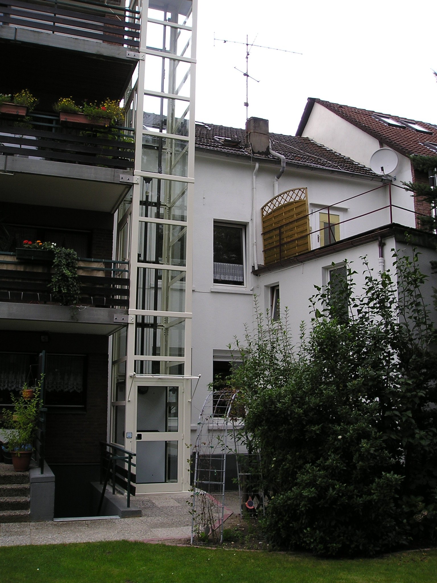 Glasaufzug mit Zugang über Balkone